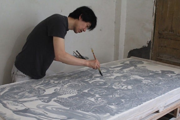 Sun Koo Yuh working on a large porcelain tile while in China in preparation for his exhibition at Gimhae Clay Arch